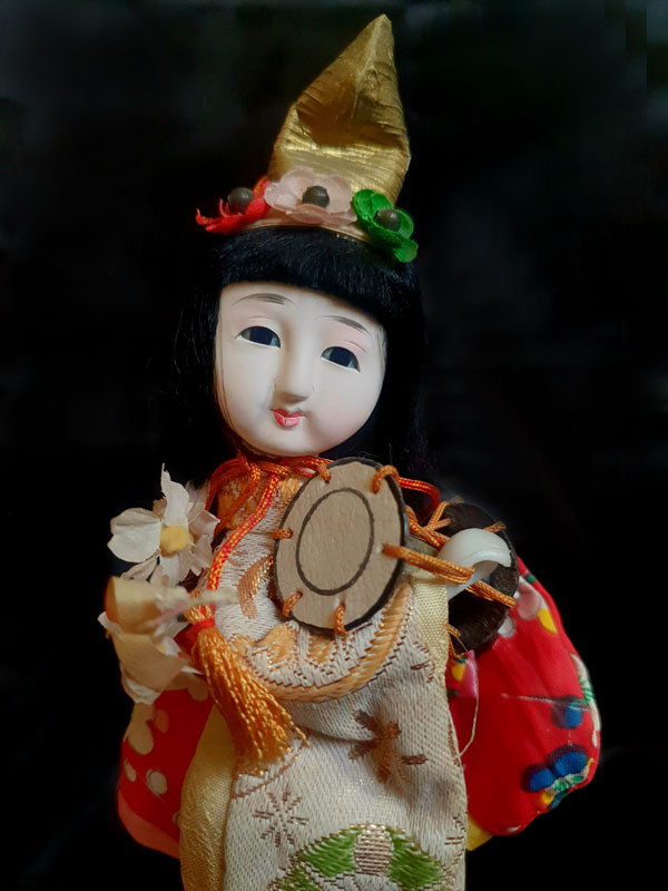 muñeca japonesa tocando el tsuzumi con hermosos ropajes